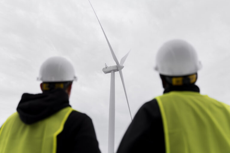 offshore workers in front of a wind turbine